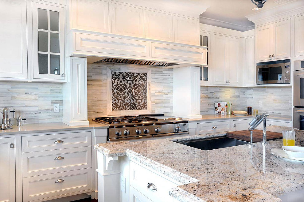 bianco romano granite countertops white shaker cabinetry slate stone backsplash hood island with sink stove