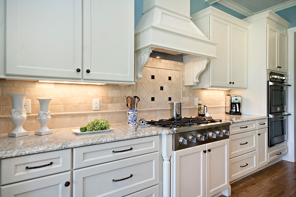 bianco romano granite kitchen countertops white shaker cabinets dark wood floor cream travertine tile backsplash