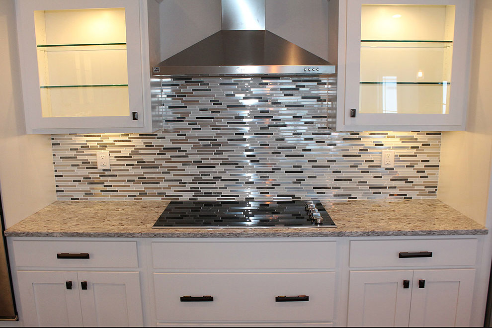 moon granite material glass front wall cabinets match stick mosaic tile backsplash black hardware hood cook top 