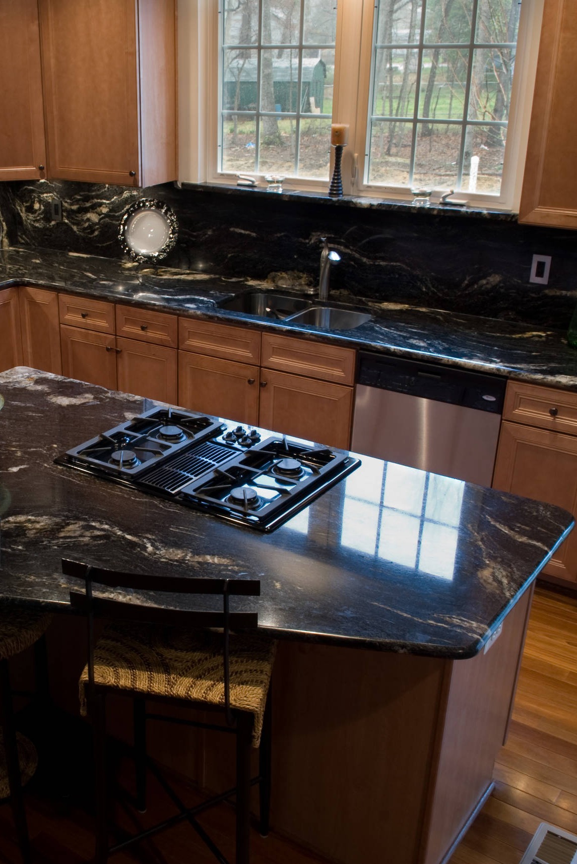 Cosmic Black Granite Countertops Full Height Slab Backsplash Brown Cabinetry Hardwood Floor