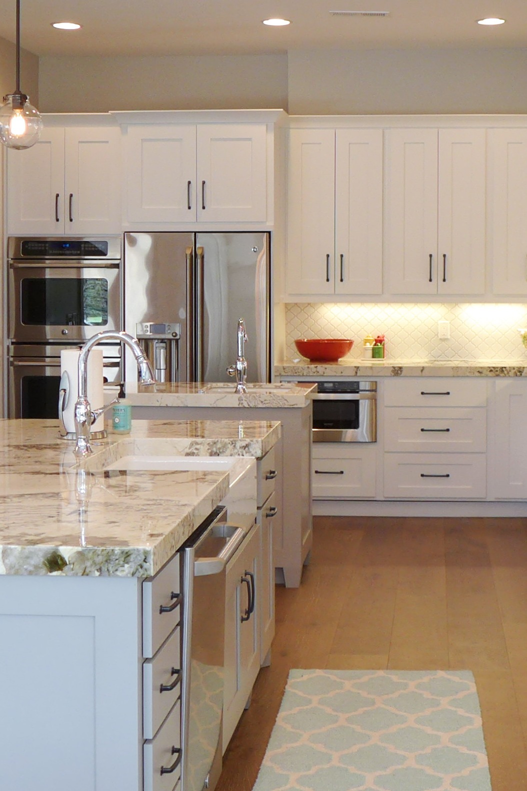 Tranquil White Tile Backsplash Cabinets Granite Countertops Light Hardwood Floor copy