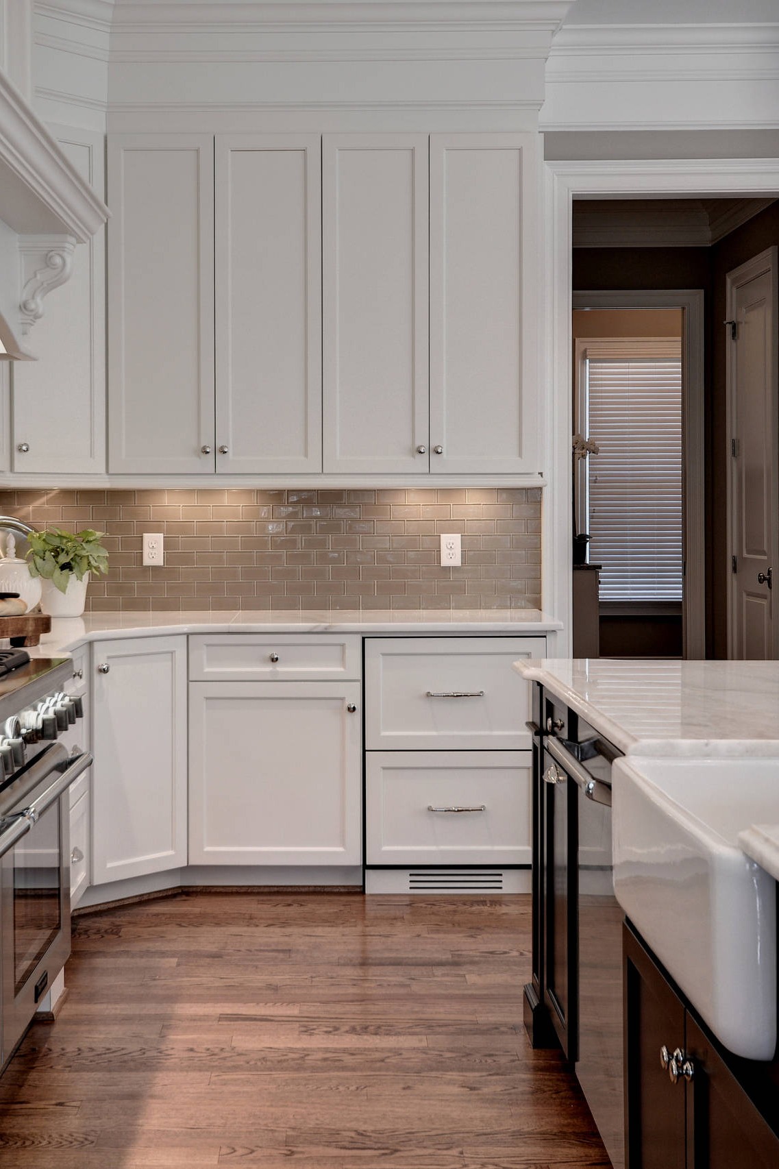 White Kitchen Cabinets White Marble Countertops Dark Hardwood Floor Brown Subway Backsplash