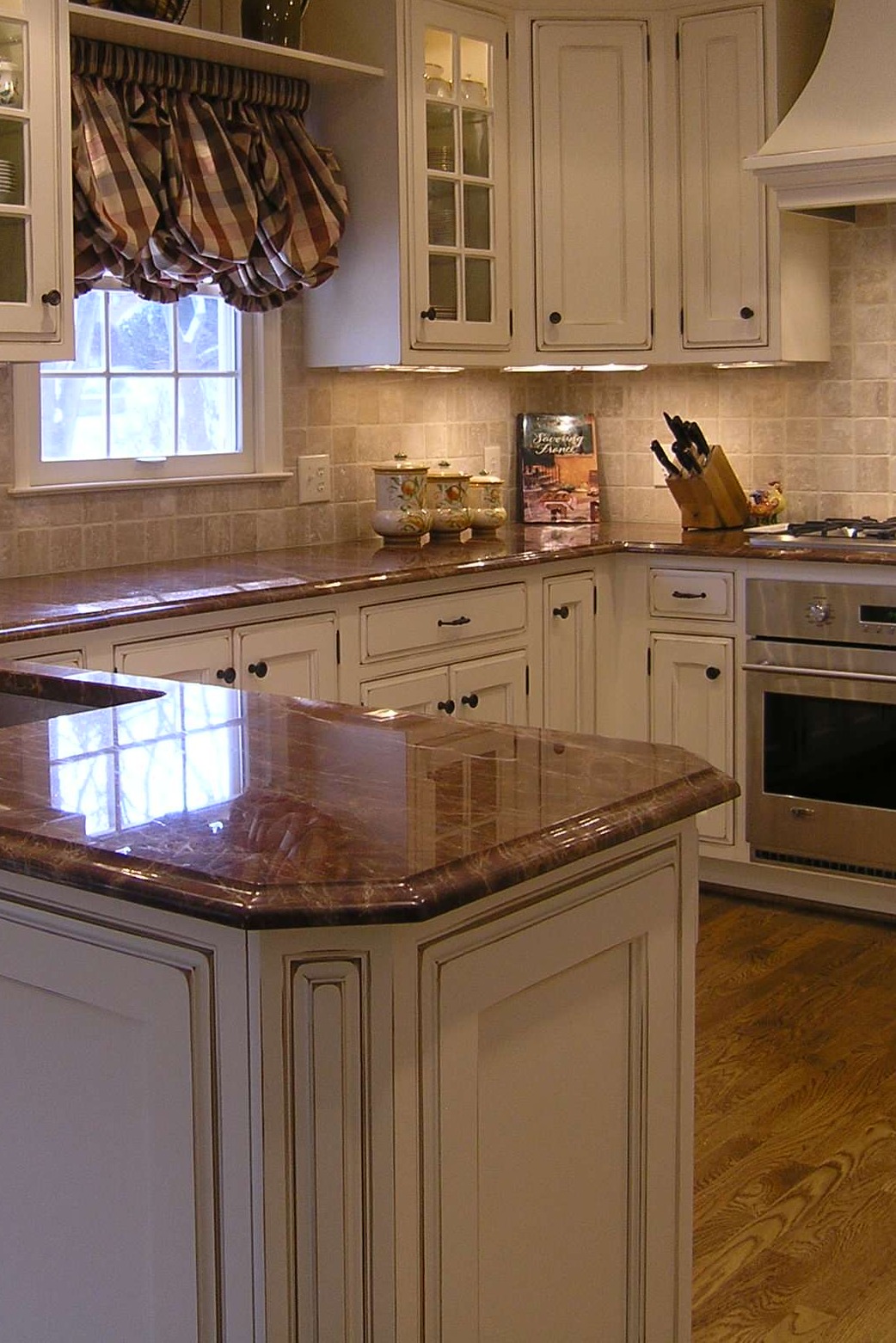 Majestic Brown Granite Countertop Glazed Cream Cabinet Travertine Backsplash Dark Hardwood Floor
