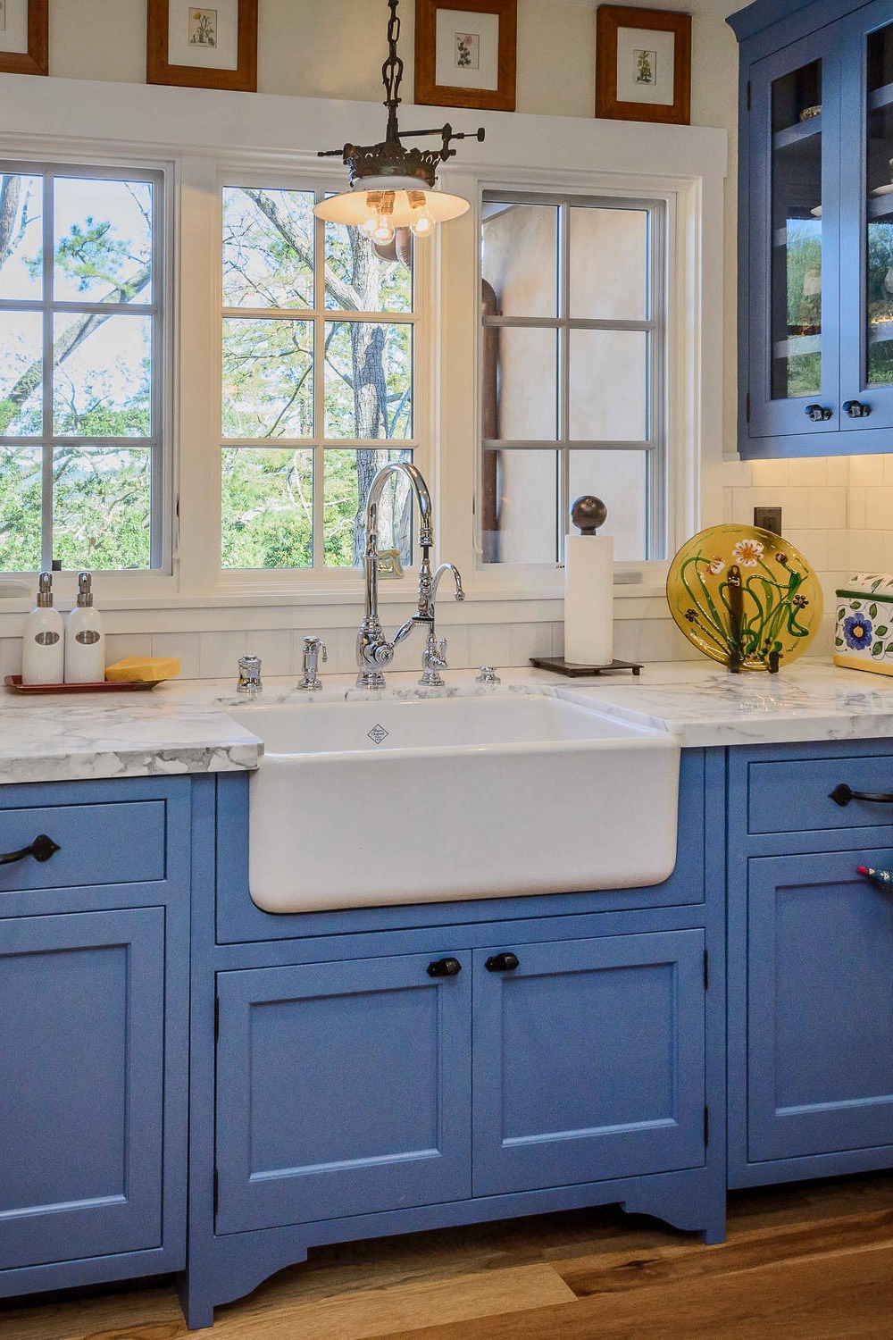 Blue Cabinetry White Countertops Farmhouse Sink Porcelain Backsplash Tile Dark Hardwood Flooring