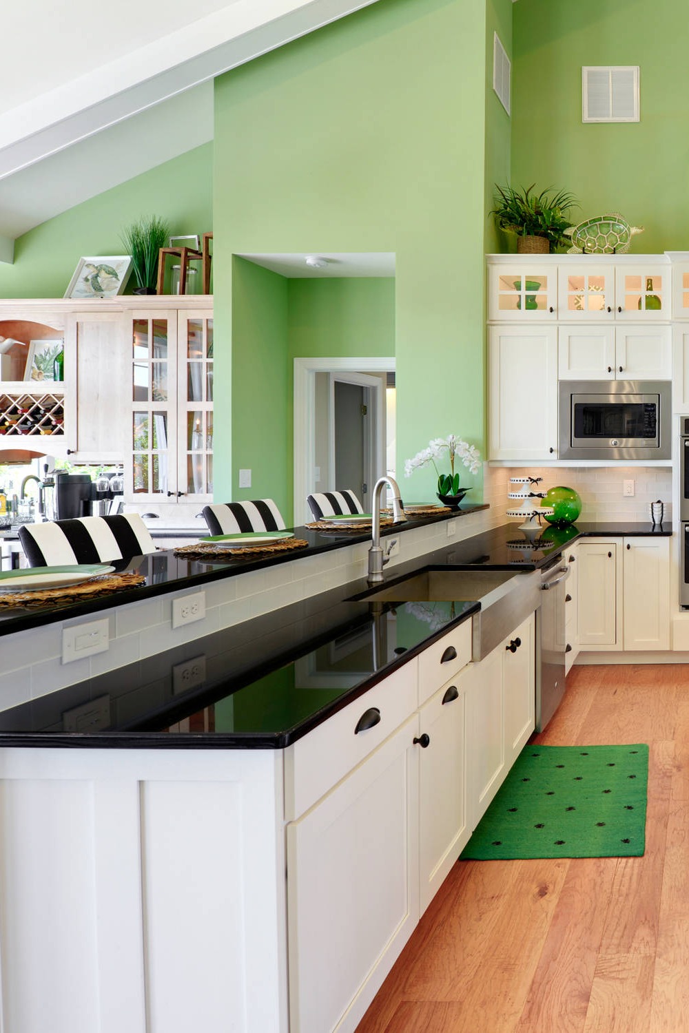 Green Wall Paint White Cabinetry Farmjouse Sink Black Countertops Hardwood Floor