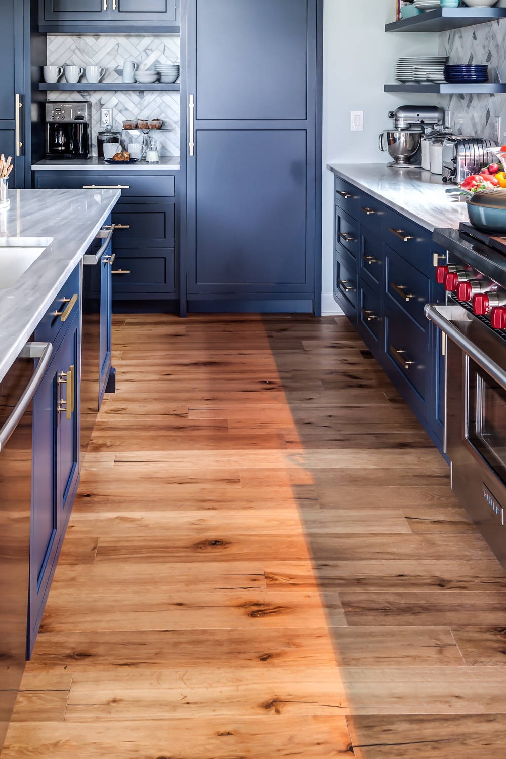 Natural Wood Hardwood Floor Blue Cabinetry Marble Subway Backsplash White Countertops