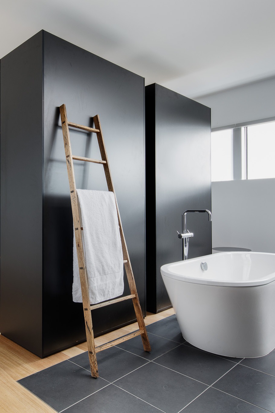Black Cabinets Medium Tone Wood Floor Freestanding Bathtub Towel Rack White Walls