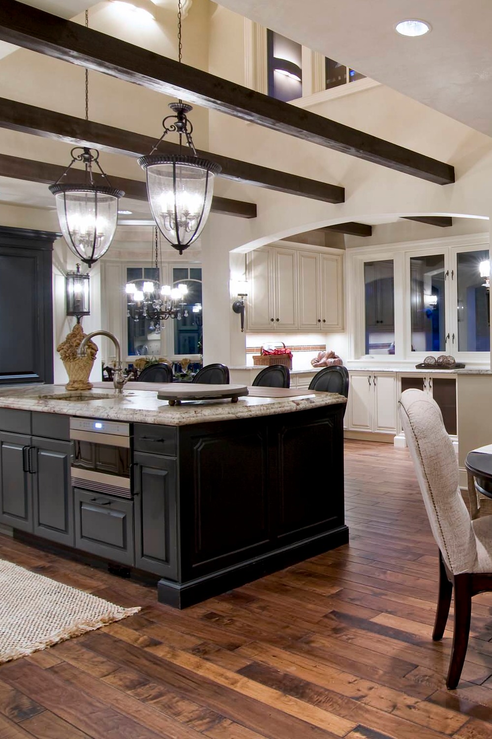 White Granite Countertops Dark Cabinets Limestone Backsplash Wood Floor Pendant Lighting Open Concept Kitchen Design