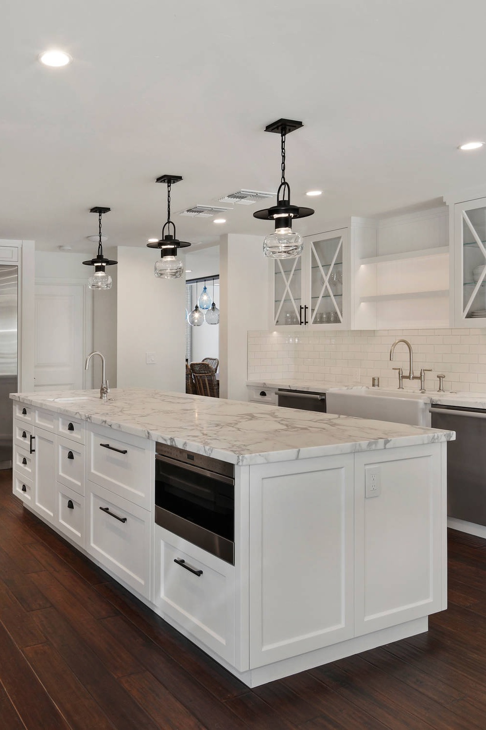 Brown Hardwood Flooring White Cabinetry Marble Counters Subway Wall Tile Pendant Lightings