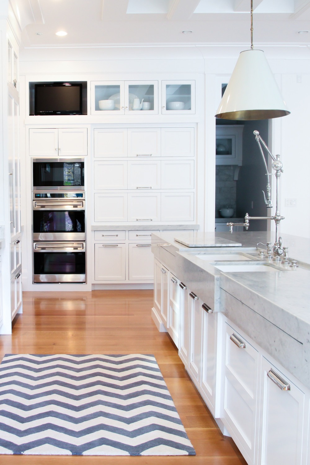 Thick White Marble Counters Shaker Cabinetry Medium Tone Hardwood Flooring