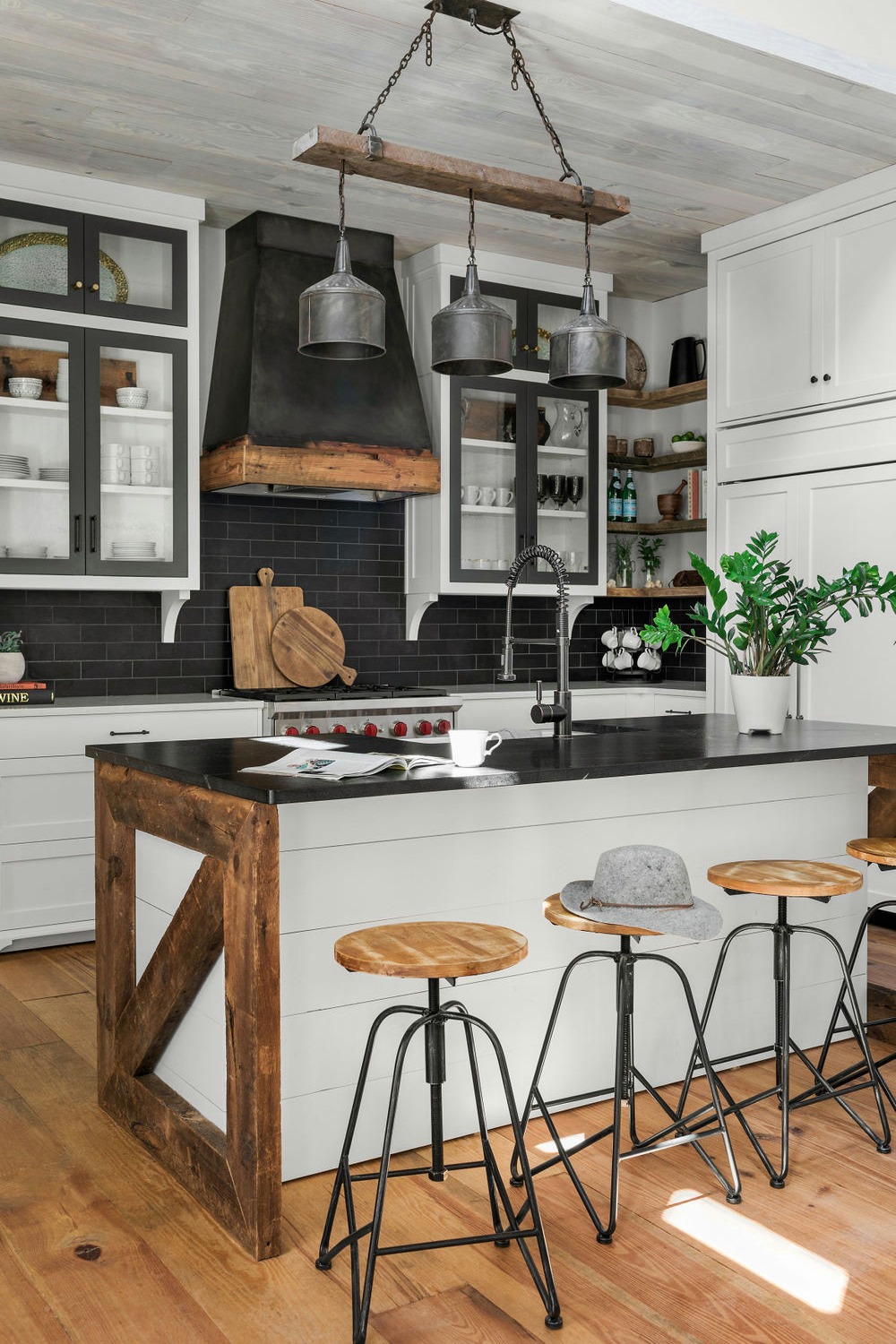 Black Quartz Counters Subway Backsplash White Cabinetry Medium Tone Hardwood Flooring