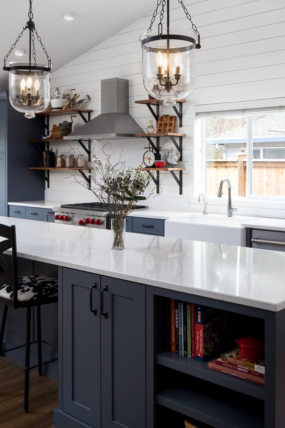 Brown Floor Blue Cabinets White Backsplash Quartz Counters Farmhouse Sink Pendant Lightings
