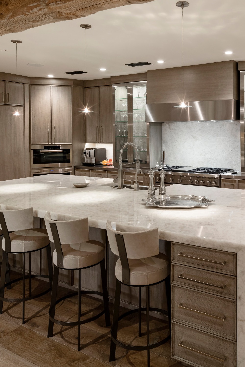 Grey Recessed Panel Cabinetry Quartzite Counters Medium Tone Hardwood Flooring White Backsplash