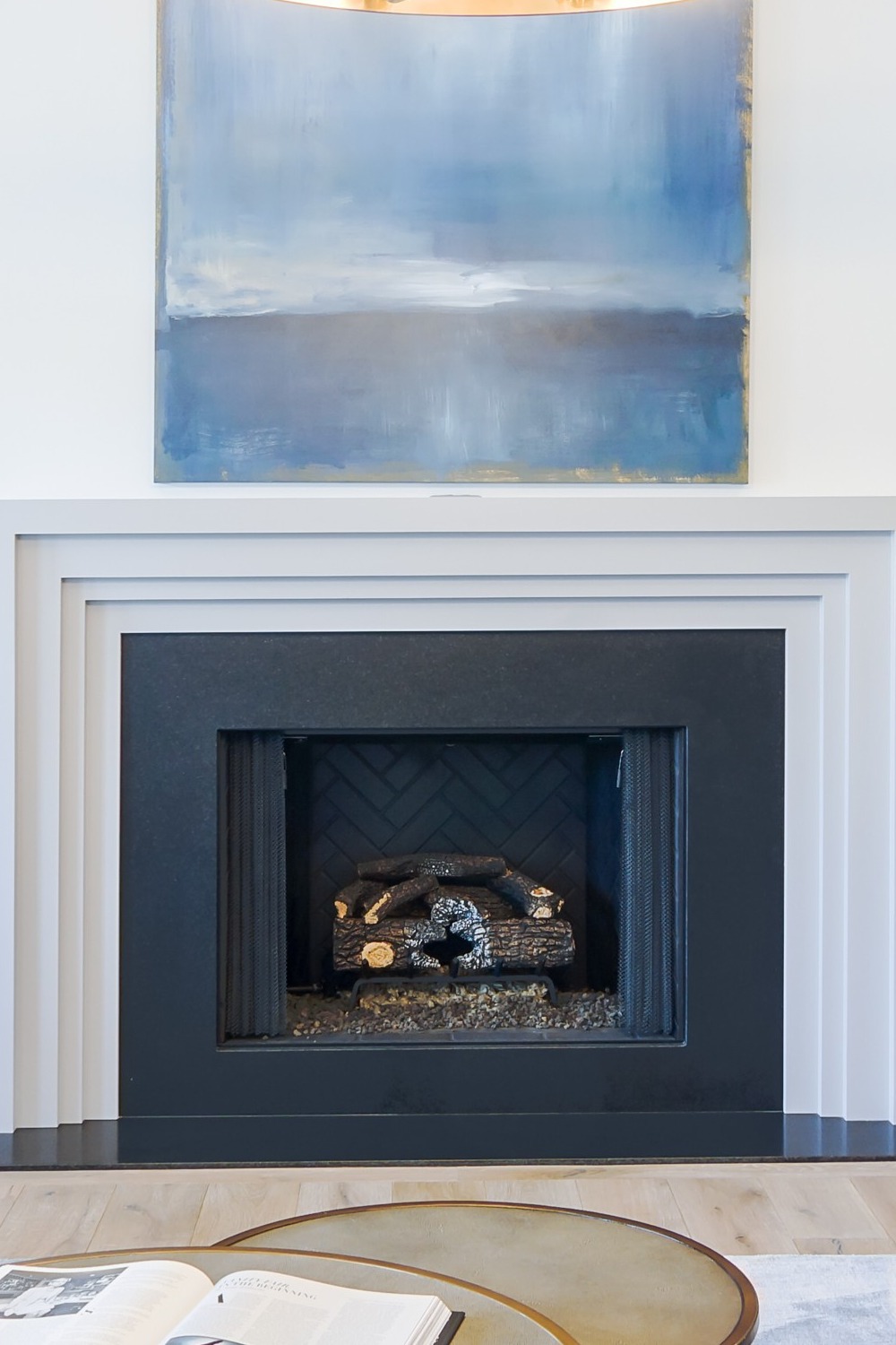 Absolute Black Granite Surrounds Layered Mantel Fireplace Light Wood Floor White Wall