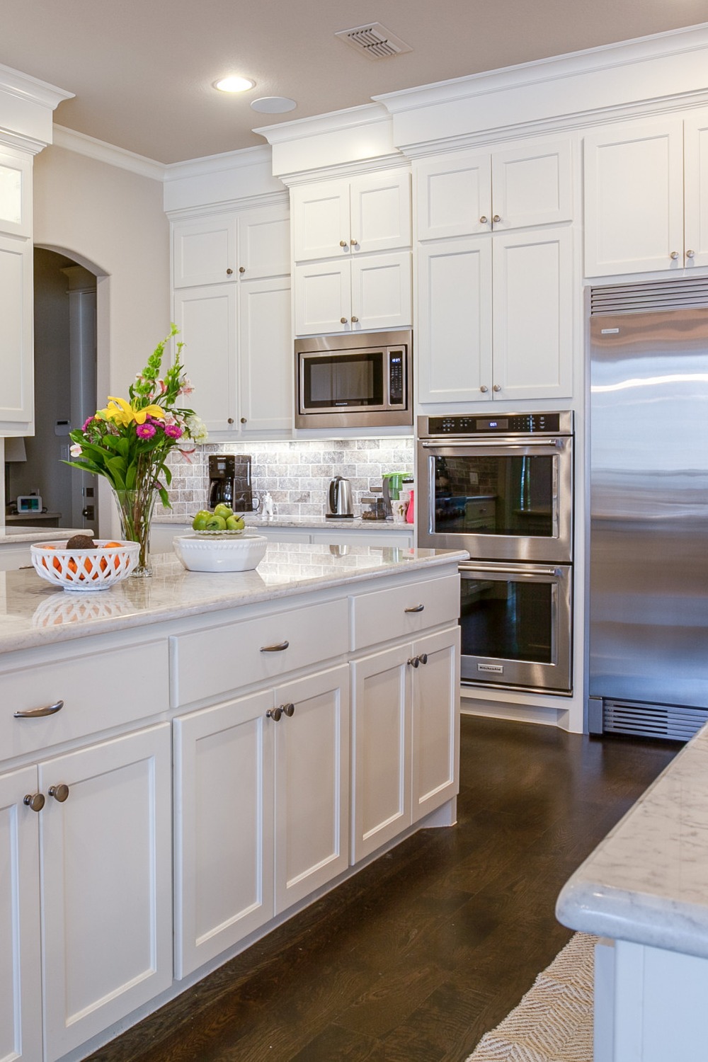White Countertops Stainless Steel Appliances White Cabinetry Whitewashed Brick Backsplash Modern Style Space