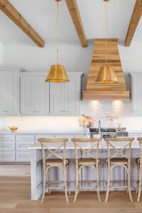 White Kitchen Cabinet Brass Hardware Brass Pendants Natural Wood Floor Bar Stools